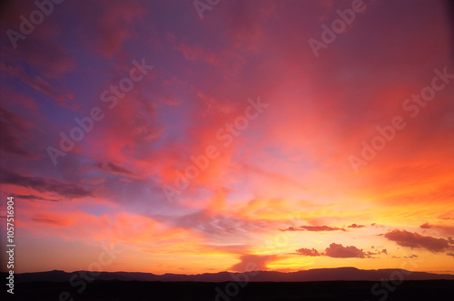 Vibrant glowing sunset sky over a silhouetted horizon