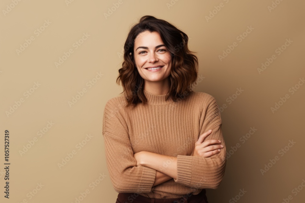 Fototapeta premium Portrait of a satisfied woman in her 30s wearing a cozy sweater over blank studio backdrop