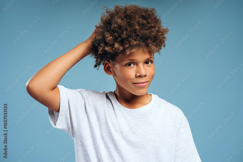 Smiling handsome African American boy with curly hair wearing white t shirt, looking at camera Smiling handsome African American boy with curly hair wearing white t shirt, looking at camera
