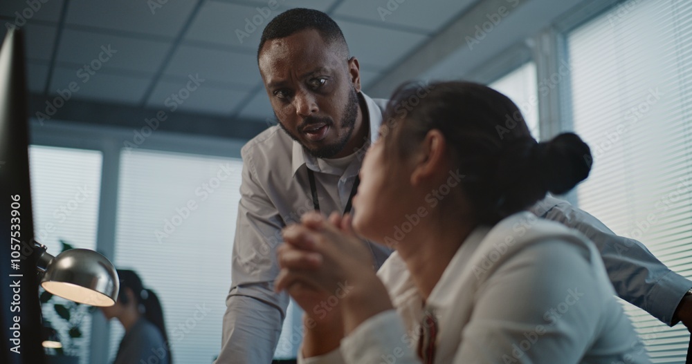 Call center office: Close up of tired Asian female helpdesk specialist holding head, feeling stressed. African American employee supports colleague. Mental health hotline. Online customer service.