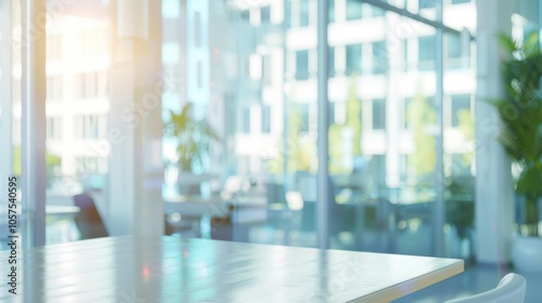 Blurred office interior background. Empty light open space office with big windows, many glasses walls, desks, chairs and green plants. Modern indoor business environment