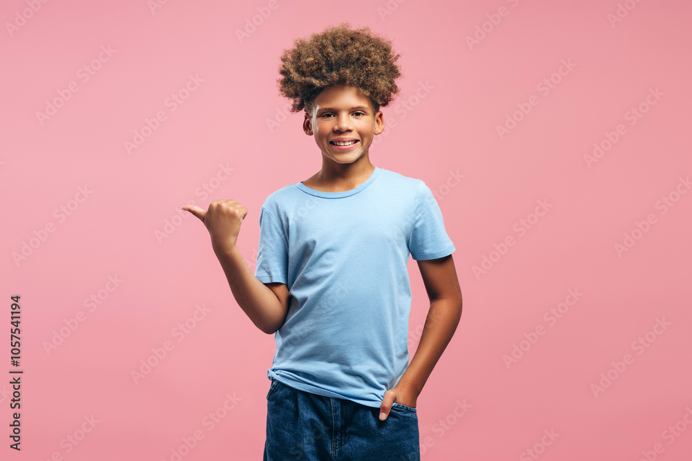 Positive African American boy with curly hairstyle wearing casual clothes pointing finger Positive African American boy with curly hairstyle wearing casual clothes pointing finger