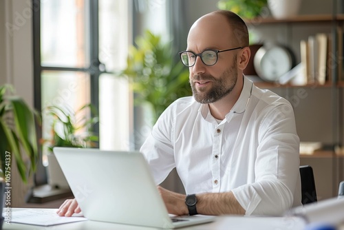 Office professional in formal wear focused on work at his computer