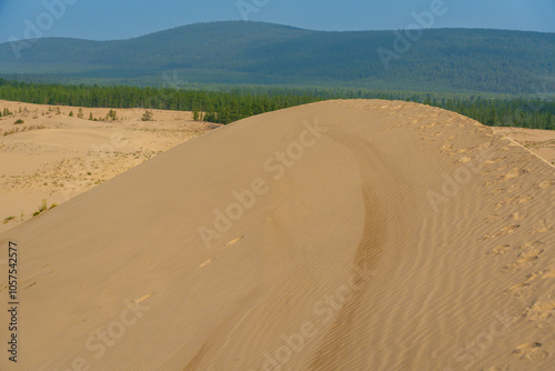 Fototapeta Naklejka Na Ścianę i Meble -  Golden desert dunes illuminated by sunbeams under a dramatic sky