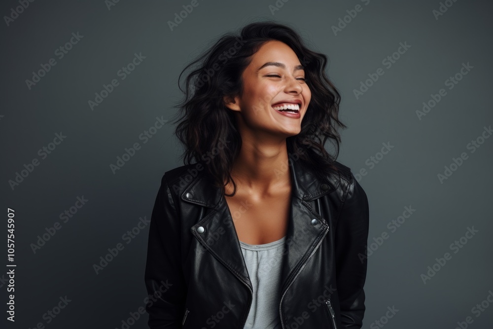 Portrait of a joyful indian woman in her 20s sporting a classic leather jacket in light wood minimalistic setup Portrait of a joyful indian woman in her 20s sporting a classic leather jacket in light wood minimalistic setup