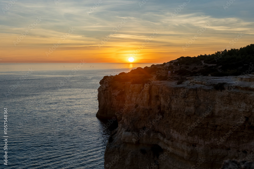 Warm sunset light over the Atlantic ocean and cliffs along the Algarve coast at Benagil Beach, Portugal; Benagil, Lagoa, Faro, Portugal Warm sunset light over the Atlantic ocean and cliffs along the Algarve coast at Benagil Beach, Portugal; Benagil, Lagoa, Faro, Portugal