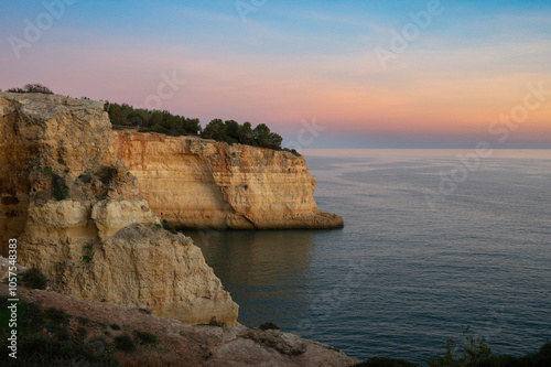 Benagil Beach at sunset, with rugged cliffs along the Algarve coast in Portugal; Benagil, Lagoa, Faro, Portugal photo