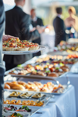 Business people enjoying a catering buffet, festive atmosphere in the background, with a low depth of field focusing on the food.