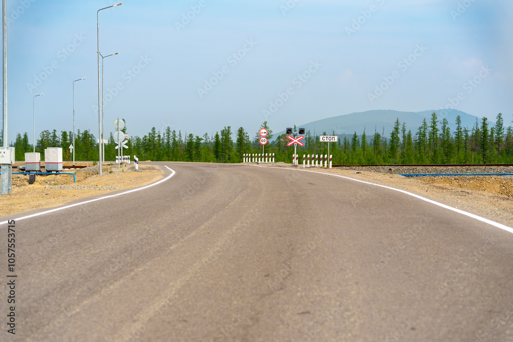 Empty road approaching railway crossing in rural area Empty road approaching railway crossing in rural area