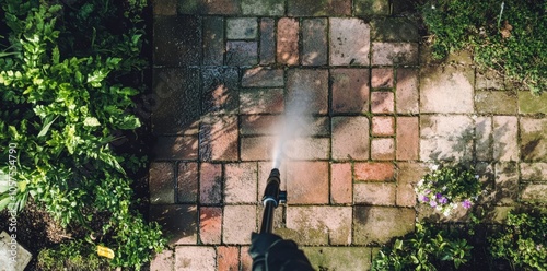 High-Pressure Cleaning of a Garden Patio on a Sunny Day photo