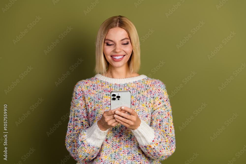 Cheerful young woman in colorful knit sweater using smartphone against khaki background, expressing happiness and connectivity, perfect for advertisement and digital lifestyle concepts Cheerful young woman in colorful knit sweater using smartphone against khaki background, expressing happiness and connectivity, perfect for advertisement and digital lifestyle concepts