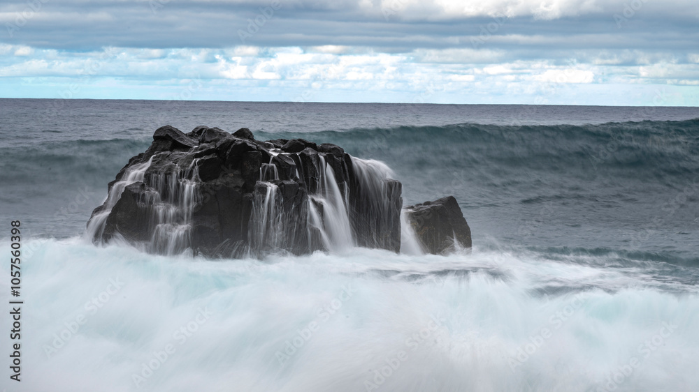 Surf and water cascading off a rock formation along the coast of the island of Madeira, Portugal; Ribeira da Janela, Madeira, Portugal Surf and water cascading off a rock formation along the coast of the island of Madeira, Portugal; Ribeira da Janela, Madeira, Portugal