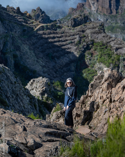 Woman stands on the trail of the rugged Pico Do Areeiro hiking destination on Maderia, Portugal; Sao Roque do Faial, Madeira, Portugal photo