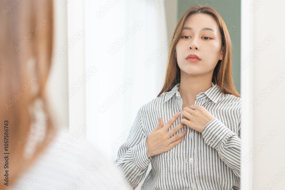 Get dress, pretty asian young woman, businesswoman standing wearing striped shirt, female getting dressed preparing before go to work looking reflection in the mirror in the morning at home. Get dress, pretty asian young woman, businesswoman standing wearing striped shirt, female getting dressed preparing before go to work looking reflection in the mirror in the morning at home.