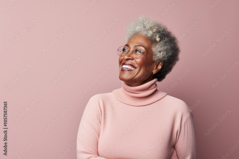 Fototapeta premium Portrait of a blissful afro-american woman in her 60s wearing a classic turtleneck sweater isolated in plain cyclorama studio wall