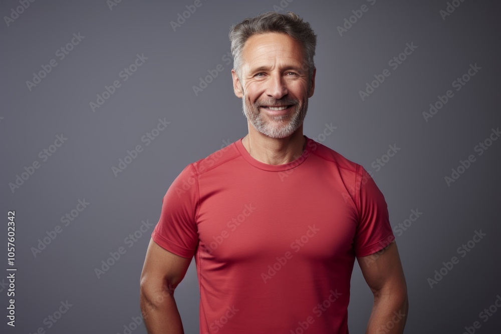 Portrait of a glad man in his 50s wearing a moisture-wicking running shirt isolated in crisp minimalistic living room