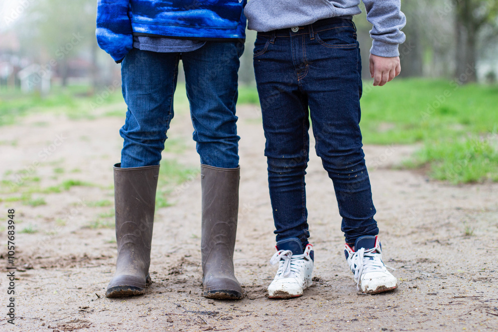 two kids legs standing in the mud two kids legs standing in the mud