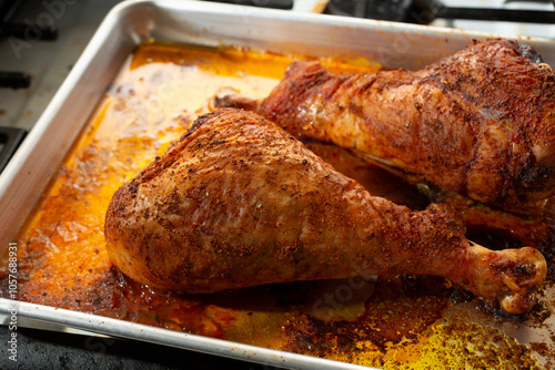 A view of a baking tray of dry rubbed baked turkey legs.