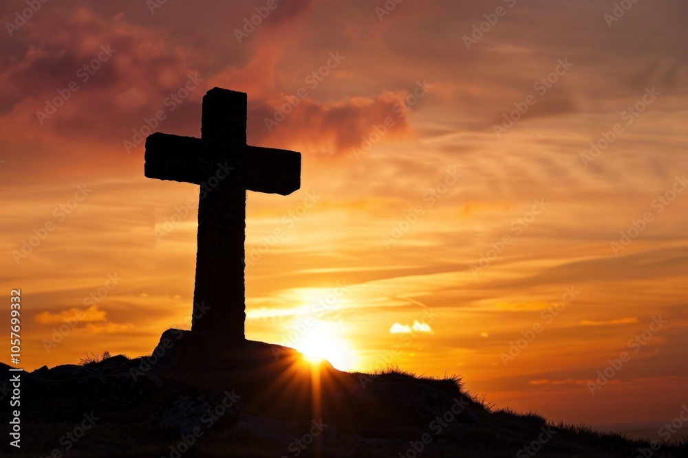 Silhouette of stone cross against vibrant sunset with dramatic sky Silhouette of stone cross against vibrant sunset with dramatic sky