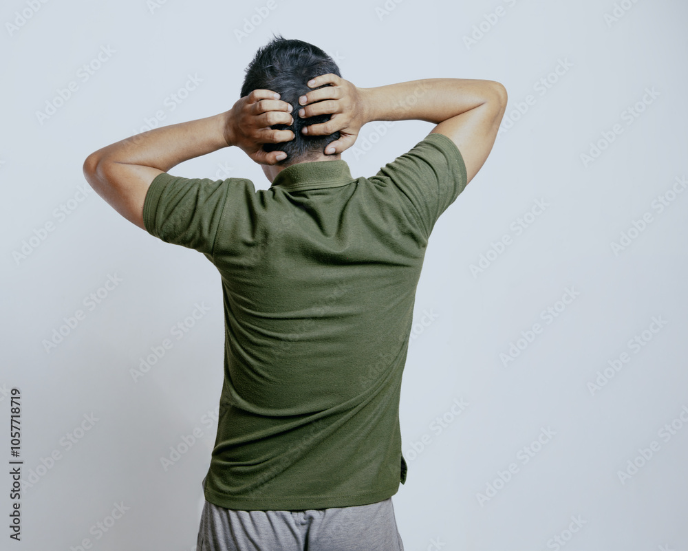 Back view of a man grabbing his head showing stress gesture.