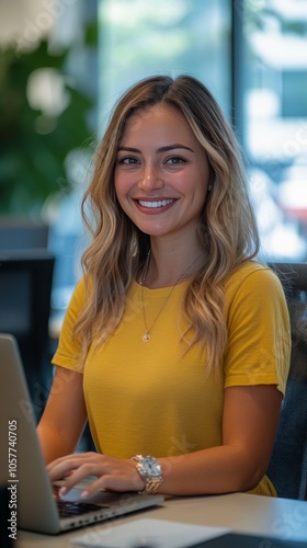 Young woman working on laptop in a bright, plant filled workspace during dayl...