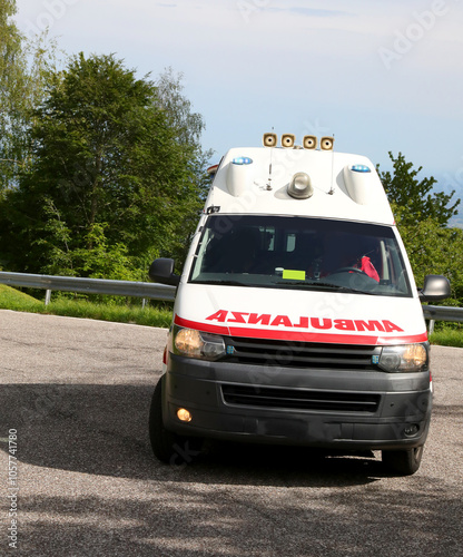 van with text reading AMBULANCE backward speeding in italian language with blue sirens flashing