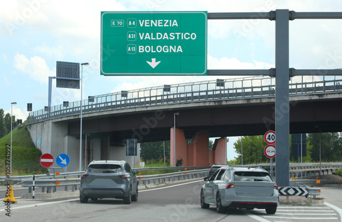 highway sign at the fork showing directions to Venezia Valdastico and Bologna with cars in ITALY photo