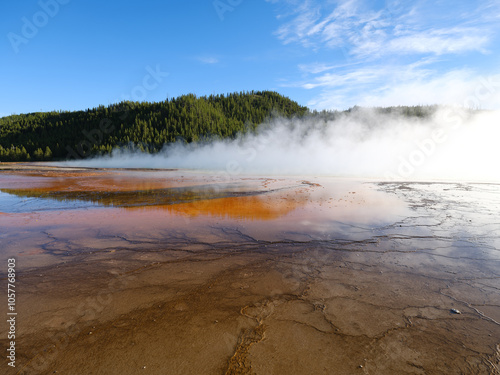 Textures and colors in the Grand Prismatic Springs of Yellowstone National Park with steam rising from the hot boiling waters That flow into the Riverhole river nearby 