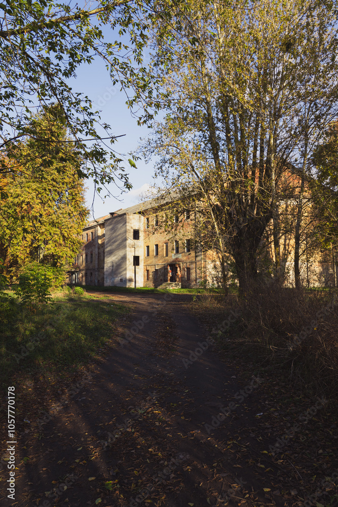 An abandoned, old building among autumn, yellow trees An abandoned, old building among autumn, yellow trees