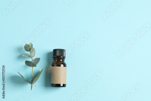 Eucalyptus essential oil in a glass bottle with green eucalyptus leaves on a color background. Aromatherapy concept. Spa. Natural organic ingredients for cosmetics and body care. photo