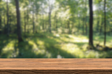 Empty wood table top with blur background of nature lush green forest. The table giving copy space for placing advertising product on the table a long with beautiful green forest nature background.