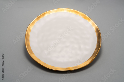  white plate with a gold rim sitting on a grey surface