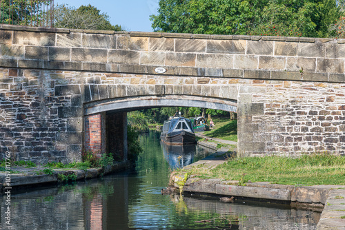 Several canal narrowboats docked along the Llangollen Canal with towpath in Trevor Basin near Pontcysyllte Aqueduct near Trevor, Wrexham, UK