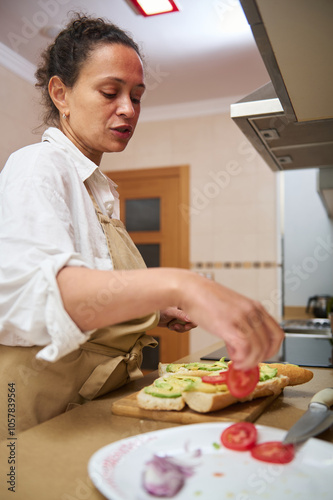 Woman preparing a healthy vegetable sandwich in kitchen