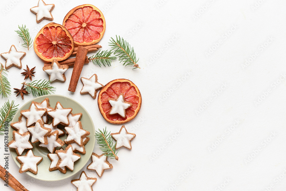 Composition with delicious stars shaped Christmas cookies, spices, orange dried pieces and fir tree branches on light background Composition with delicious stars shaped Christmas cookies, spices, orange dried pieces and fir tree branches on light background