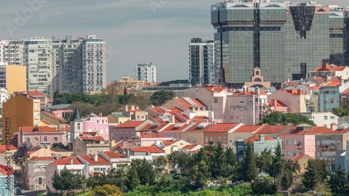 Aerial view of Lisbon skyline with Amoreiras shopping center towers. Historic buildings near Campo de Ourique district with green trees timelapse from Monsanto viewpoint. Lisbon, Portugal photo