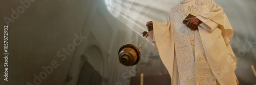 Website banner with unrecognizable priest holding Bible and majestic golden censer while besmoking nave