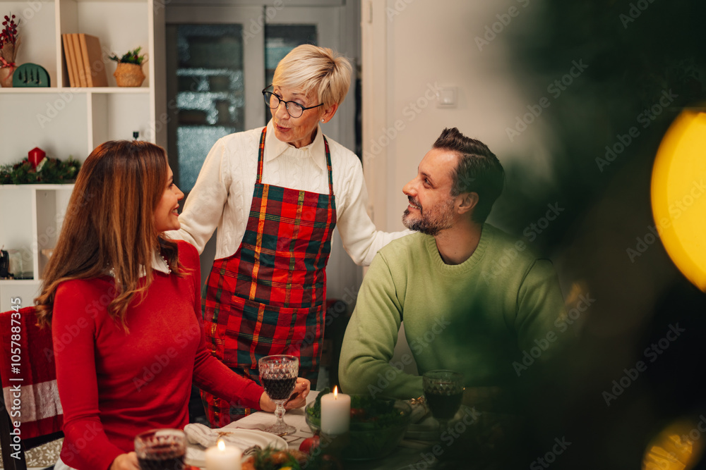 Senior woman bringing christmas dinner to family smiling at table Senior woman bringing christmas dinner to family smiling at table