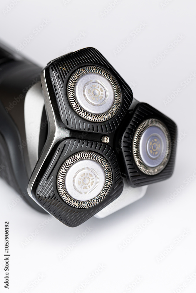 Beard electric shaver on a white background. Close-up of the cutting blades. Photo taken in artificial light with clearly visible details of the shaver