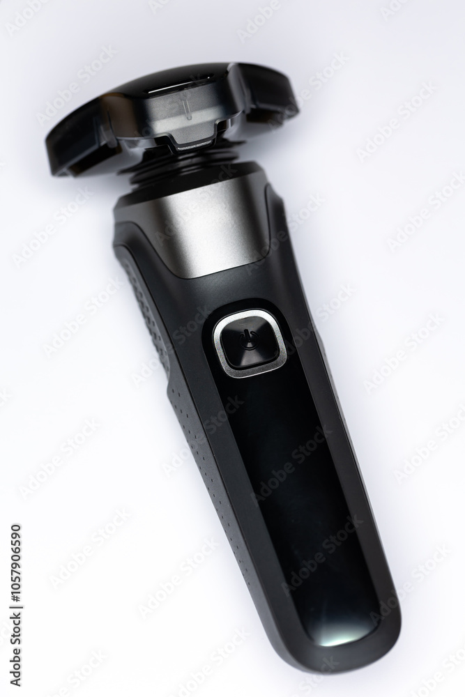 Beard shaver on a white background. Cutting blades protected by plastic cover. Photo taken in artificial light with clearly visible details of the shaver