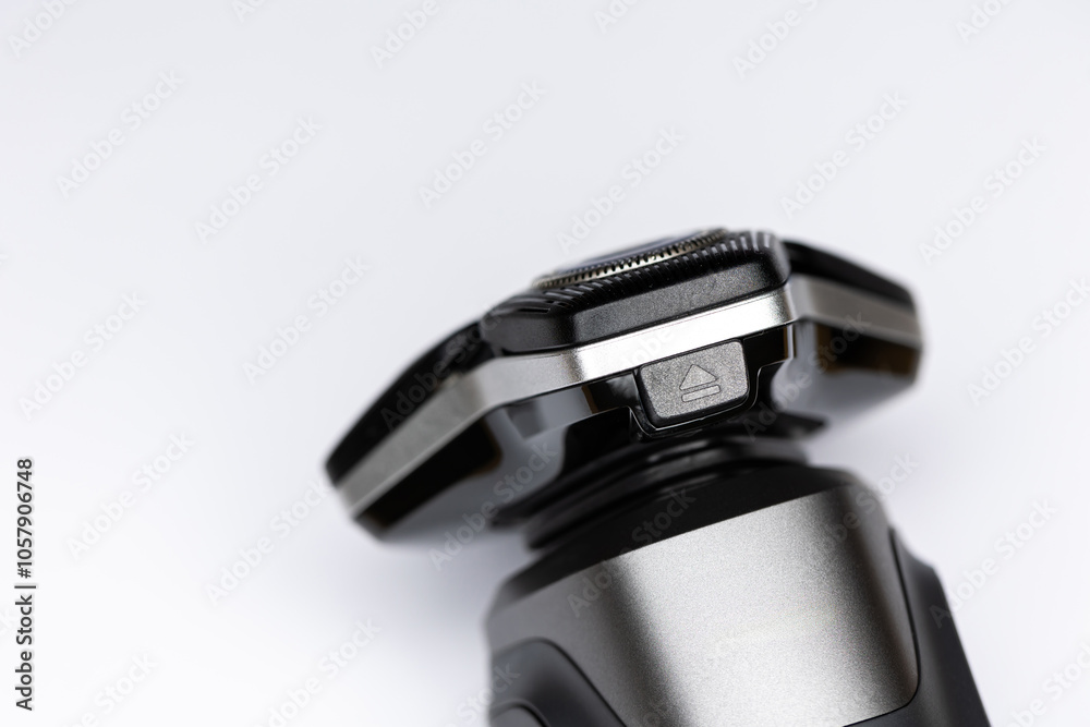 Beard electric shaver on a white background. Close-up of the cutting blades. Photo taken in artificial light with clearly visible details of the shaver