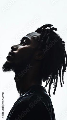 Profile of a man with dreadlocks against a bright background showcasing stron...