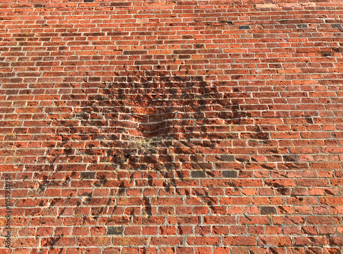 Traces of war - shrapnel, bullets marks on the red bricks wall. Old, medieval castle wall in Malbork, Poland 