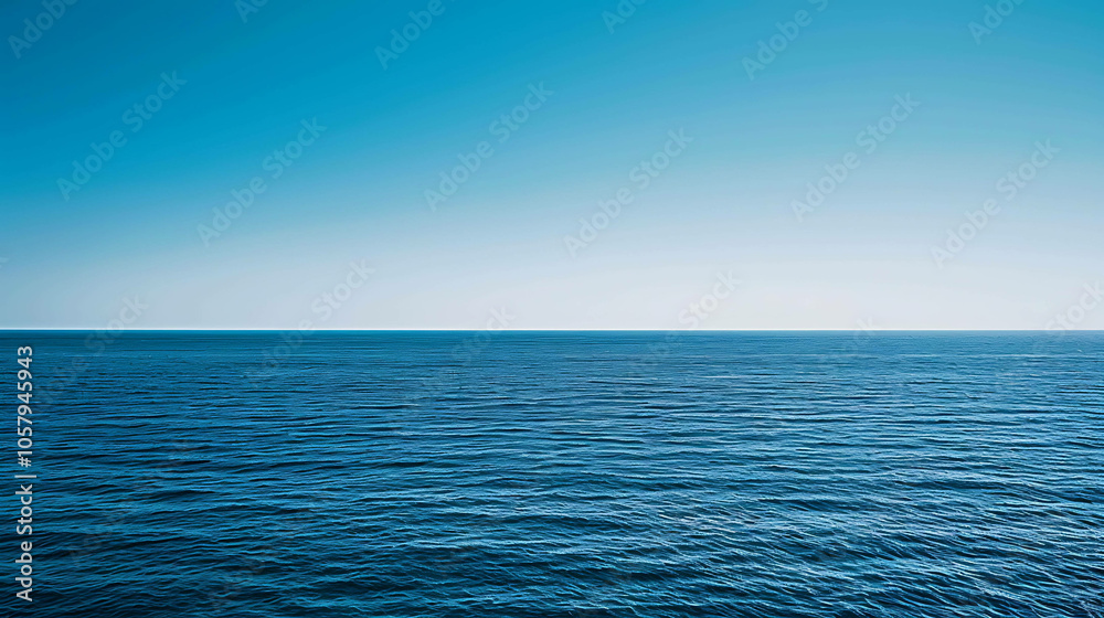 Obraz premium Deep blue ocean with a clear blue sky. The water is calm and still.