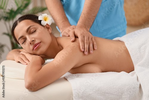 Young woman getting massage on couch in spa salon