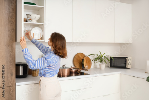 Young woman taking glass fr...