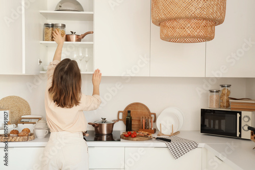 Young woman taking jar of p...