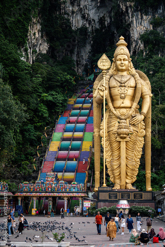 Photography Large golden statue of the Hindu god Murugan stands tall outside of the Batu Cav