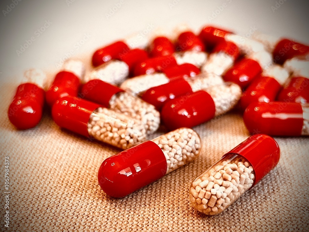 Red and transparent medication capsules containing pancreatic enzyme