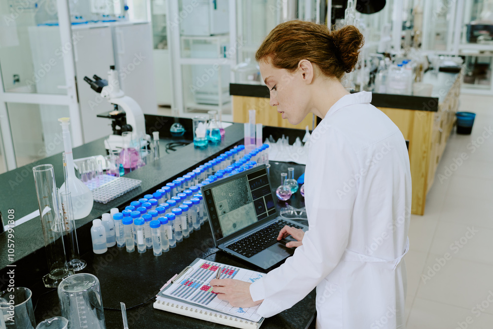 Female scientist working with lab equipment and analyzing data on a laptop surrounded by scientific instruments in a modern laboratory setting Female scientist working with lab equipment and analyzing data on a laptop surrounded by scientific instruments in a modern laboratory setting